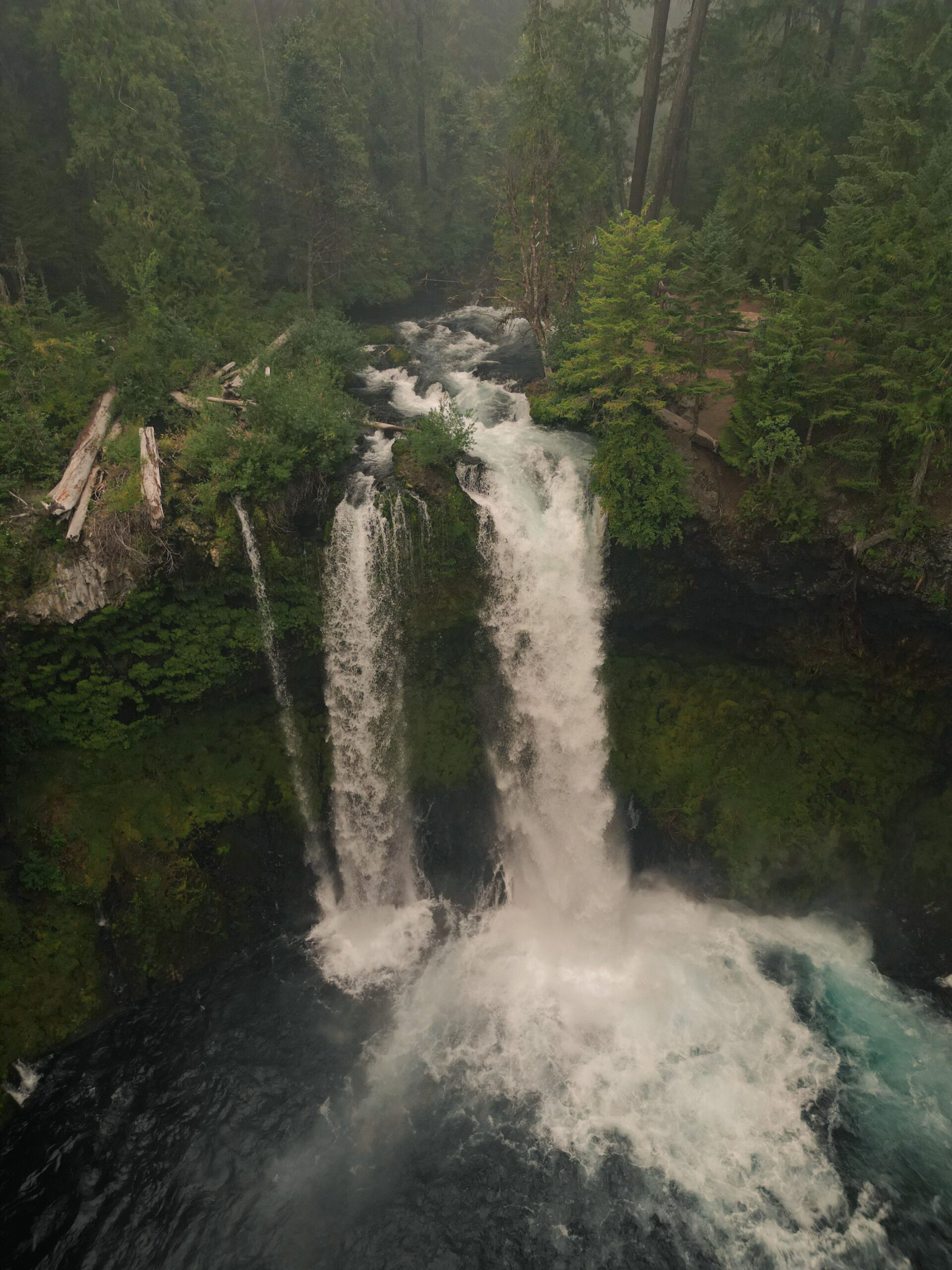 A stunning aerial view of a waterfall cascading through lush forests in Oregon, United States.
